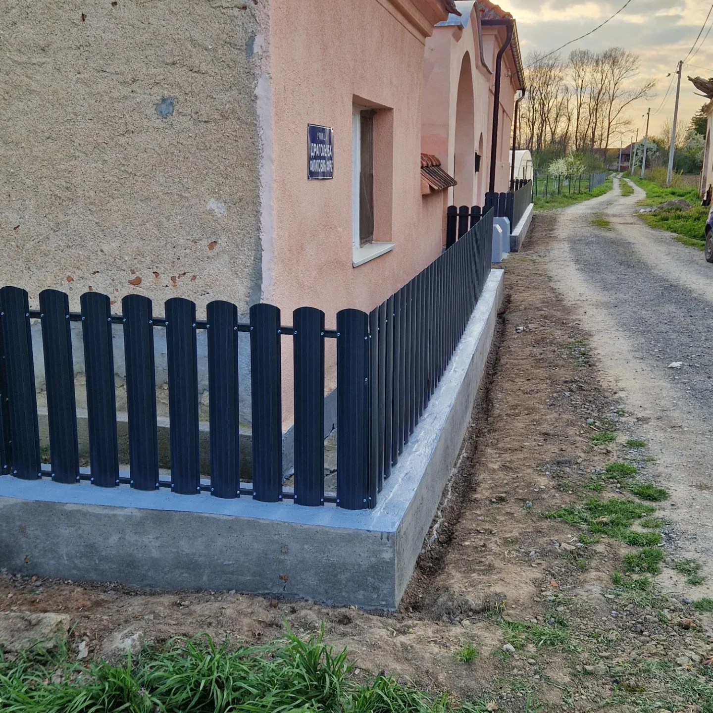 Ograda sa vertikalnim letvama zaobljenih vrhova na betonskoj podlozi